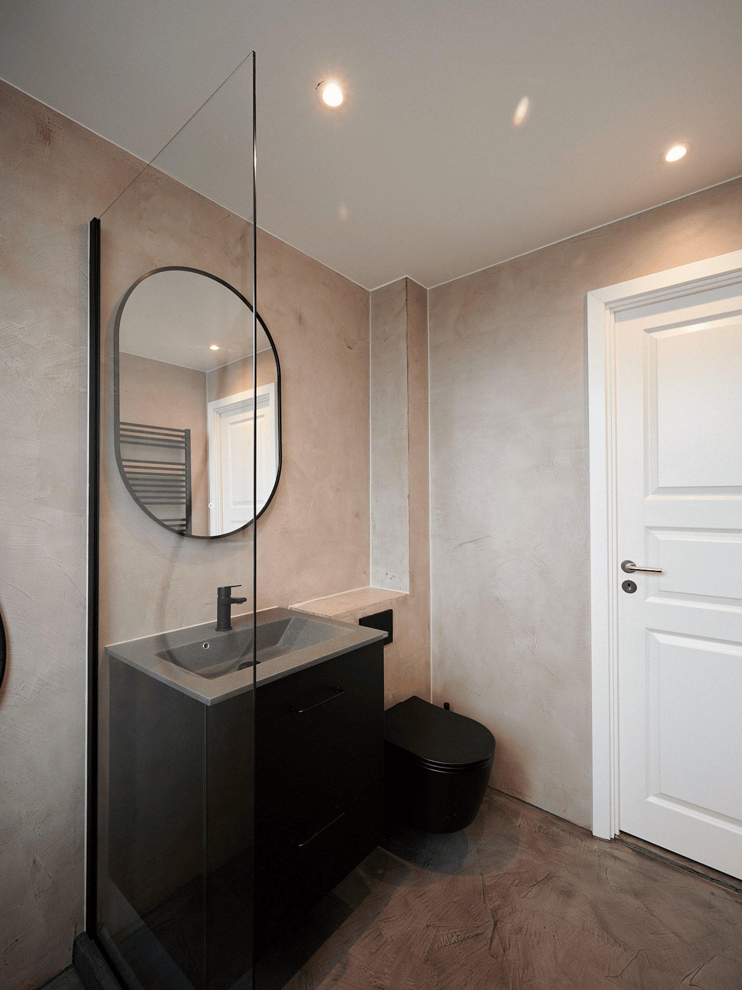 Microcement-toilet med spejl og sort vask
